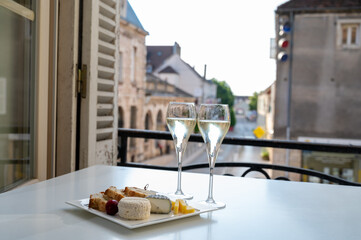 Romantic party with two glasses of white cold champagne and view on old street in French village