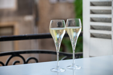 Romantic party with two glasses of white cold champagne and view on old street in French village