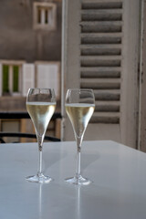 Romantic party with two glasses of white cold champagne and view on old street in French village