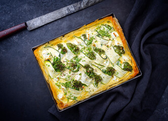 Traditional French Tarte with zucchini and baby broccoli served as top view in backing form