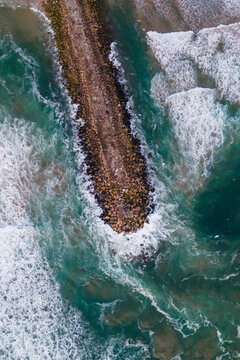 Aerial view of  water waves rolling on the beach at Costa da Caparica, Setubal, Portugal