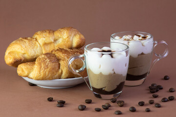 Breakfast with croissants and cappuccino on a blurry brown background