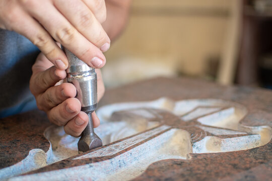 caucasian man hands bushhammered a tombstone in a workshop, work concept
