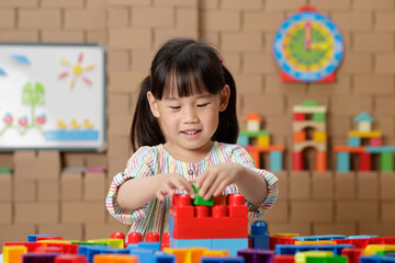 young irl playing creative toy blocks at home