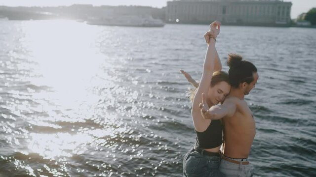 A couple standing in front of a body of water