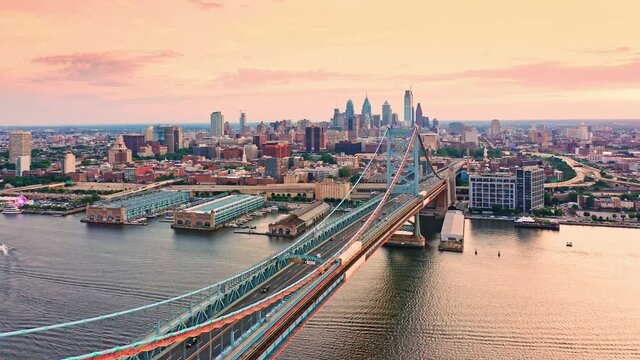 Aerial view Ben Franklin Bridge and Philadelphia skyline with slow camera pull-back, at sunset. Ben Franklin Bridge is a suspension bridge connecting Philadelphia and Camden, NJ.