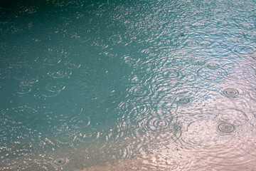Rain drops in a turquoise pool