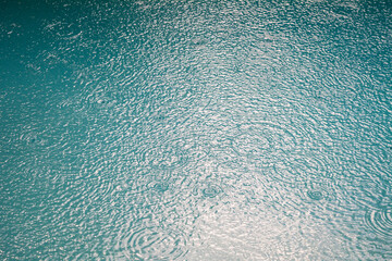 Rain drops in a turquoise pool