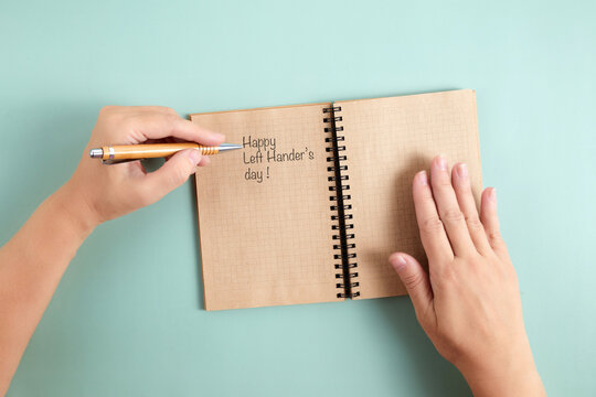 Happy Left Hander's Day. Left hand hold pen and writing text. - Powered by Adobe