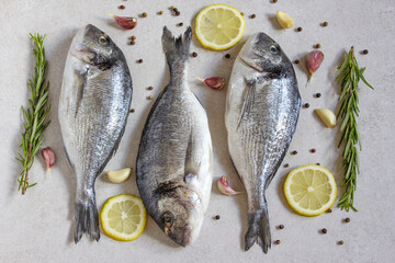 Two fresh raw sea organic dorado or sea bream with spices and lemon