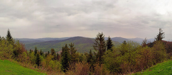 Beautiful landscape showing panoramic view from top of Wielki lubon hill top. Mountain and hill surrounded with green trees against dramatic clouds during rainy weather.located near rabka, Poland - obrazy, fototapety, plakaty