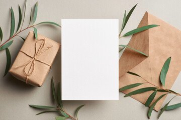 Invitation or greeting card mockup with envelope, gift box and fresh eucalyptus twigs