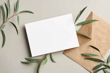 Invitation or greeting card mockup with envelope and fresh eucalyptus twigs