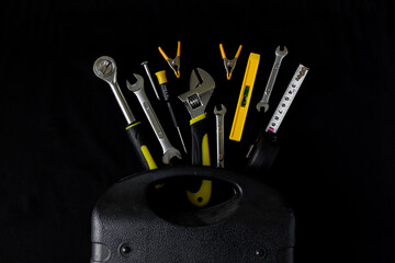 Maintenance, construction tools on black, dark background.