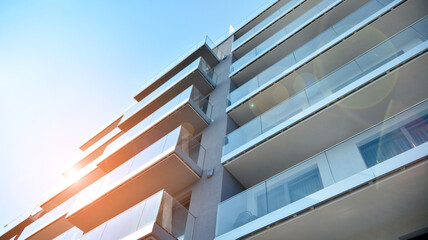 New apartment building with glass balconies. Modern architecture houses by the sea. Large glazing on the facade of the building.