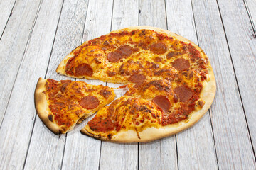 Great spicy Italian pepperoni pizza with a slice cut out ready for a good bite