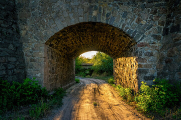 Fototapeta na wymiar Old stone bridge and the light of the evening sun