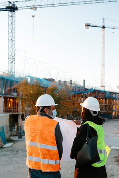 Woman engineer and construction worker with face masks