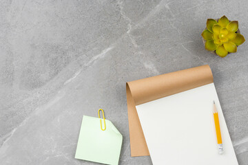 Open notepad on gray marble background.