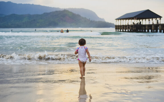 Brave child walking into ocean waves