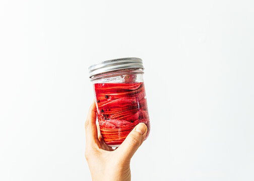 Hand Holding Jar Of Pickled Watermelon Radish