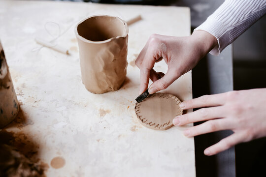 Artist incising clay detail 