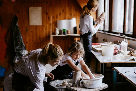 Child crafting pottery in art studio 