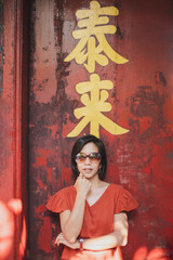 Asian woman wearing red shirt standing pose thinking