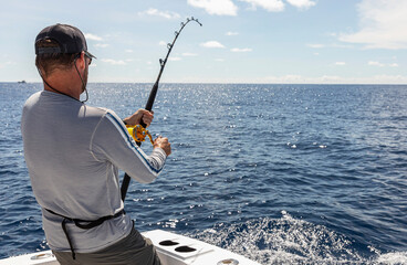 Man  Reeling in Sportfish on Boat 