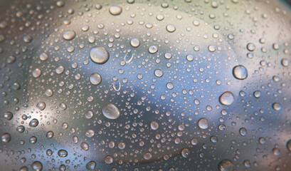 close-up shot of water droplets on shiny silver surface, background or texture concept.