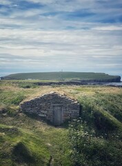 Fisherman Hut at Skiba Geo with Brough of Birsay in the distance. - obrazy, fototapety, plakaty