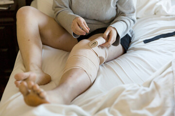 Woman wraps bandage around leg