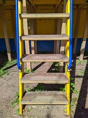 wooden ladder on the playground in the summer park at daytime.