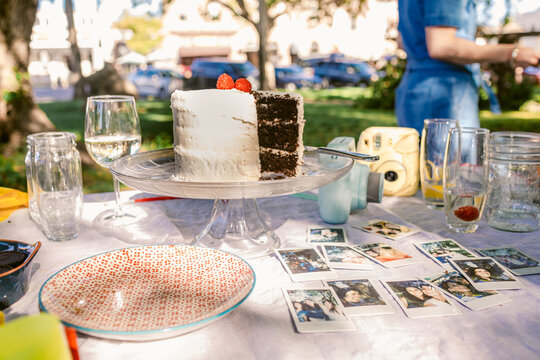Picnic table served with instants photos and cake in Park