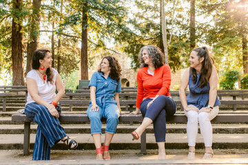 Friendly women laughing together in park