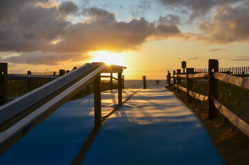 Fototapeta na wymiar Accessible beach mats on walkway to Cape Cod beach. Sunrise Ocean Beach view.