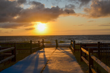Fototapeta premium Accessible Beach mats on Walkway to Cape Cod Beach. Sunrise Ocean Beach view.