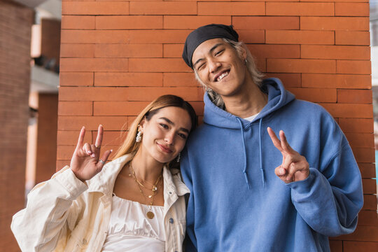 Cheerful diverse couple gesticulating and smiling for camera