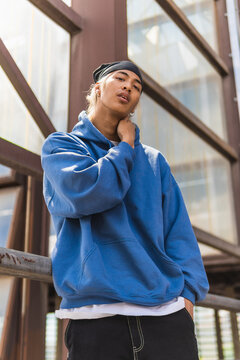 Stylish Asian guy leaning on railing