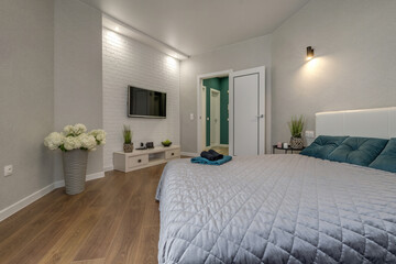  Interior of the modern luxure bedroom in studio apartments in gray light color style and green pillows