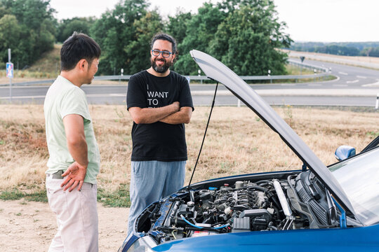 Two Men In Front Of The Open Car Hood