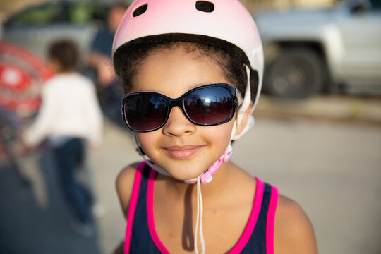 A pretty child wearing large sunglasses and a helmet