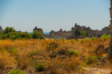 Fototapeta na wymiar SIDE, TURKEY: Ancient ruins in the city of Side on a sunny summer day against the background of the blue sky.