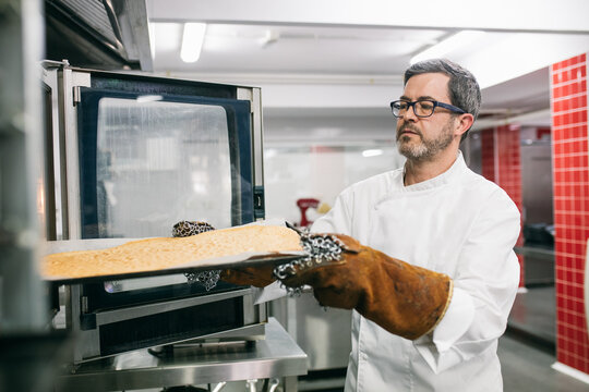 Man placing cooking tray in oven 