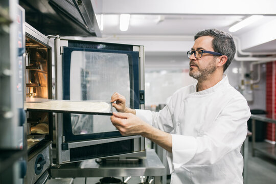 Man placing cooking tray in oven 