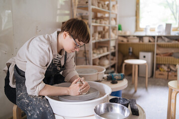 young woman working in a pottery workshop