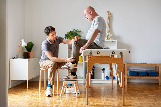 An osteopath examining patient's leg
