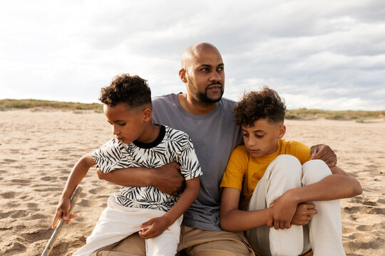 Father with his children relaxing on the beach