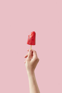 Woman holding tasty red strawberry ice cream on stick