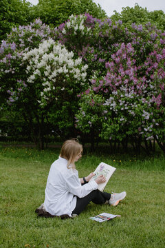 Blonde woman painting in the park